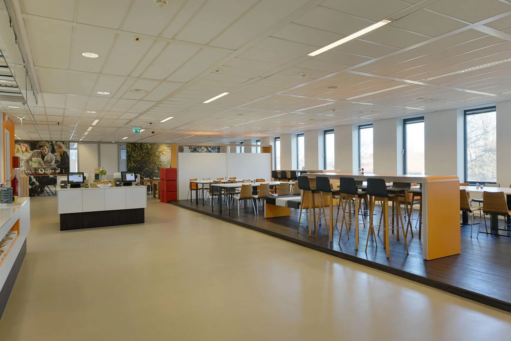 Modern ingerichte bedrijfsruimte aan de Laan van Zuid Hoorn met werkplekken, zitgedeelte en zelfbedieningskiosk.